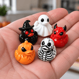 Mini Halloween duck figurines shown in a hand for scale